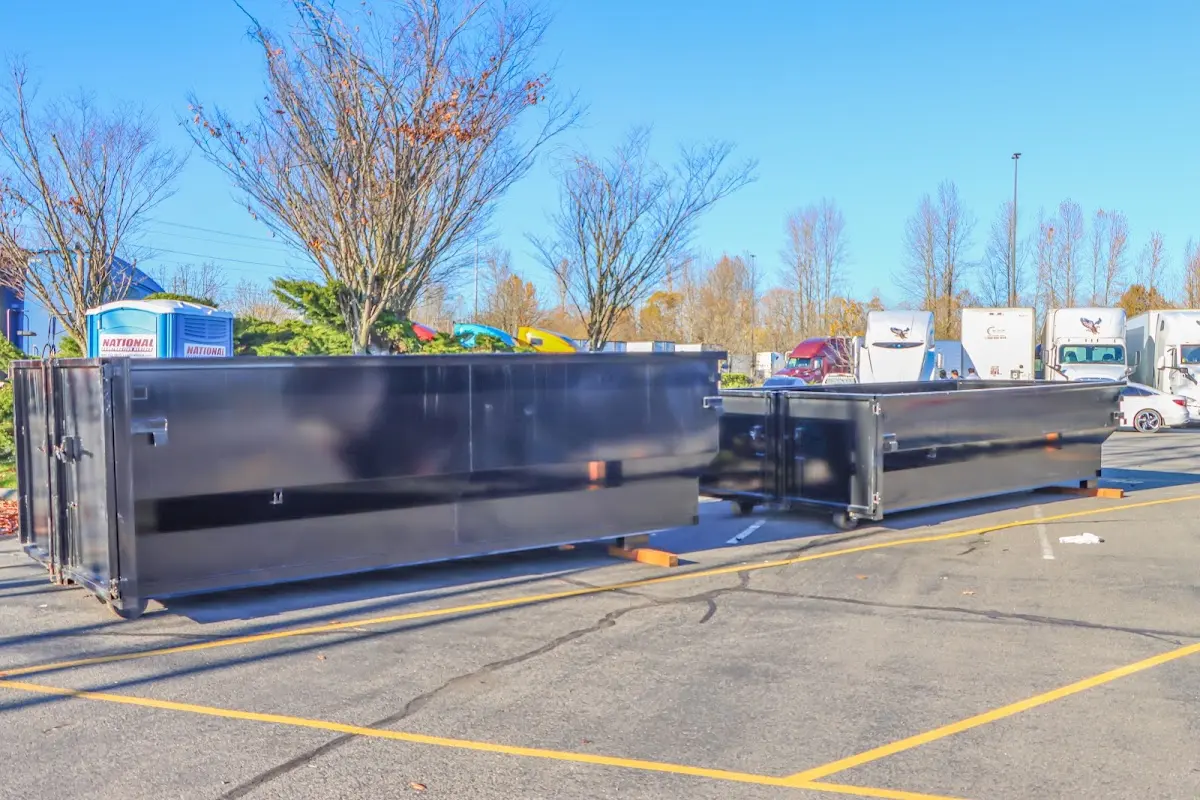 Professional dumpster rental service with roll-off container on residential driveway in Ishpeming